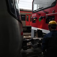 作業用の灯りを付けて連結作業をするE5000（右）。左は12－000形＝東京都大田区で2025年2月3日、渡部直樹撮影