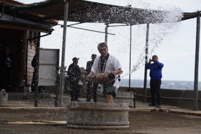能登半島地震と能登豪雨を乗り越えて始まった、道の駅「すず塩田村」の塩作り。神事で清められた塩田に、職人が海水をまいた＝石川県珠洲市で2025年4月25日午前10時38分、岩本一希撮影