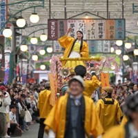 昭和レトロがテーマの「夕日の丘商店街」で東京ブギウギの曲に乗り、歌って踊って観客を盛り上げるキャストたち＝埼玉県所沢市の西武園ゆうえんちで2025年4月26日、手塚耕一郎撮影