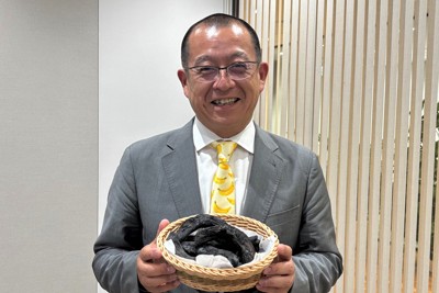 規格外のバナナを炭に加工した「バナナ炭」を持つ、ドールの青木寛社長＝東京都中央区で2025年4月17日午後5時14分、鴨田玲奈撮影