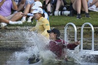 Mao Saigo, of Japan, in yellow, jumps into the water after winning the Chevron Championship LPGA golf tournament on April 27, 2025, in The Woodlands, Texas. (AP Photo/Eric Gay)