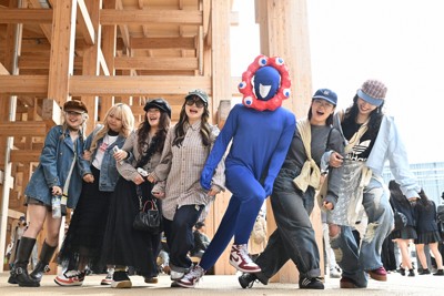 集まってきた人たちとの記念撮影に応じるミャクミャクの格好をした来場者＝大阪市此花区で2025年4月25日、大西岳彦撮影