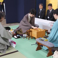 立会の福崎文吾九段（左）が開封した封じ手を指す藤井聡太名人（中央）。右は挑戦者の永瀬拓矢九段＝大阪府泉佐野市のホテル日航関西空港で2025年5月10日午前8時59分、西村剛撮影