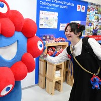 万博会場の「ミャクミャクハウス」で来場者とタッチを交わすミャクミャク＝大阪市此花区で2025年4月25日、大西岳彦撮影