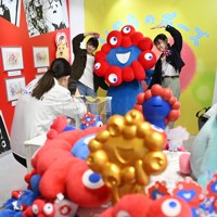 万博会場の「ミャクミャクハウス」で来場者との記念撮影におさまるミャクミャク（奥）＝大阪市此花区で2025年4月25日、大西岳彦撮影