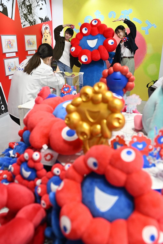 万博会場の「ミャクミャクハウス」で来場者との記念撮影におさまるミャクミャク（奥）＝大阪市此花区で2025年4月25日、大西岳彦撮影