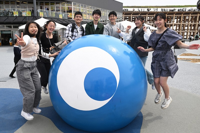 モニュメントを囲んで記念撮影する来場者＝大阪市此花区で2025年4月25日、大西岳彦撮影