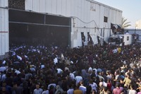 WFPの倉庫に殺到し、小麦粉の袋を持ち去るパレスチナの人＝パレスチナ自治区ガザ地区中部ザワイダで2025年5月28日、AP