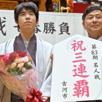 4勝1敗で名人戦3連覇を果たし、記者会見で花束を手に笑顔を見せる藤井聡太名人（左）と針谷力古河市長＝茨城県古河市の山水はなももプラザで2025年5月31日午前0時59分、手塚耕一郎撮影