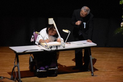 筆談でメッセージを伝える胎児性水俣病の古山知恵子さん＝新潟市中央区で2025年5月31日午後1時56分、戸田紗友莉撮影
