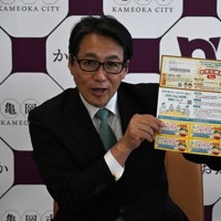 「お米引換券」と亀岡市内で使える8000円分のクーポン券の見本を紹介する桂川孝裕市長＝京都府亀岡市役所で2025年6月2日午後1時19分、南陽子撮影