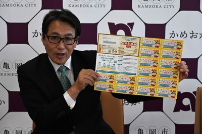 「お米引換券」と亀岡市内で使える8000円分のクーポン券の見本を紹介する桂川孝裕市長＝京都府亀岡市役所で2025年6月2日午後1時19分、南陽子撮影