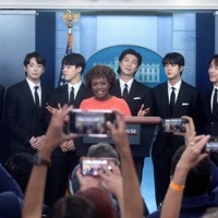 米ホワイトハウスの記者会見室を訪れ、報道官の紹介を受けるBTSメンバー＝ワシントンで2022年5月31日、ロイター