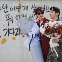1年6カ月の兵役を終えて除隊したBTSのジェイホープさん（右）を花束を手に迎えたジンさん＝韓国・原州市の軍施設で2024年10月17日、ロイター