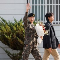 1年6カ月の兵役を終え、除隊後に手を振るジェイホープさん＝韓国・原州市の軍施設で2024年10月17日、ロイター