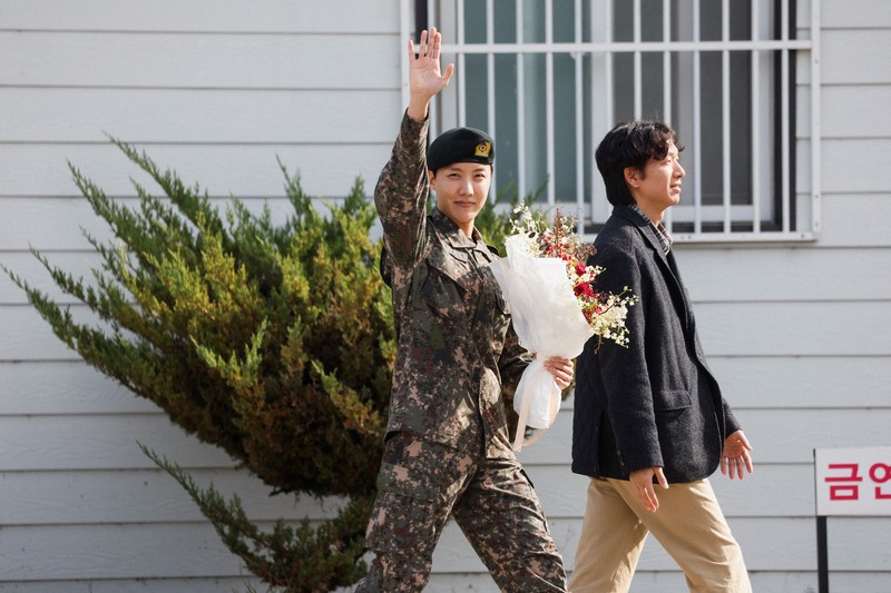 1年6カ月の兵役を終え、除隊後に手を振るジェイホープさん＝韓国・原州市の軍施設で2024年10月17日、ロイター