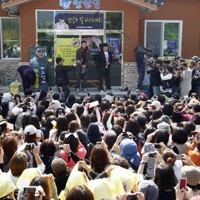 兵役のため入隊する陸軍新兵教育隊前で、ファンにあいさつする韓国の人気歌手のRain（ピ）さん＝韓国・議政府市で2011年10月11日、ロイター