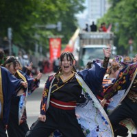 はじけんばかりの笑顔で演舞する踊り子たち＝札幌市中央区の大通パレード会場で2025年6月8日午後2時47分、伊藤遥撮影