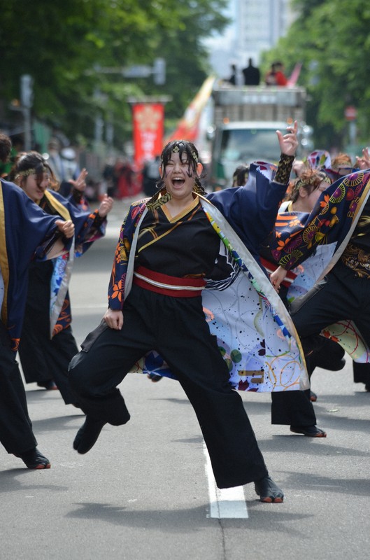 はじけんばかりの笑顔で演舞する踊り子たち＝札幌市中央区の大通パレード会場で2025年6月8日午後2時47分、伊藤遥撮影
