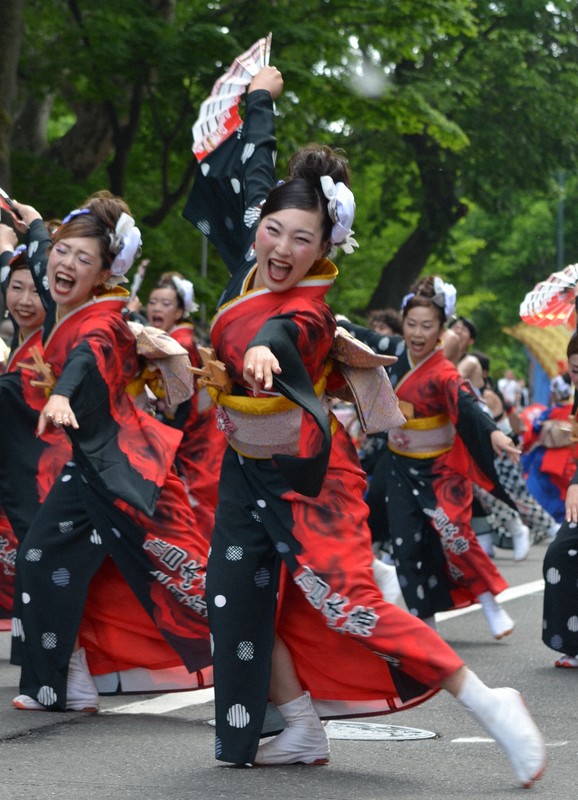 元気いっぱいの表情で群舞を披露する踊り子たち＝札幌市中央区の大通パレード会場で2025年6月8日午後3時2分、伊藤遥撮影