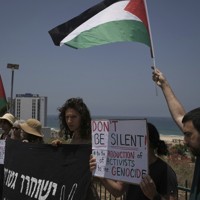 パレスチナの旗を振るグレタ・トゥーンベリさんらの支持者=イスラエル中部アシュドッドの港近くで2025年6月9日、AP