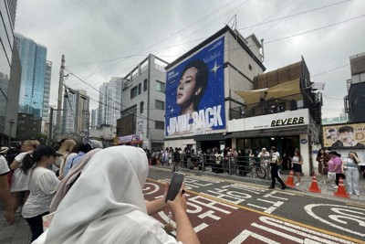 BTSのRMさんとVさんの除隊を祝い、所属するHYBE本社前に集まったファンら。奥の建物に掲げられたのは6月11日除隊予定のジミンさんの写真＝ソウル市内で2025年6月10日午前、堀山明子撮影