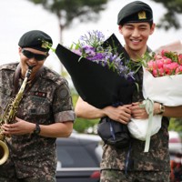 兵役を終えたBTSのRMさん（左）とVさん＝韓国北部・春川で2025年6月10日、ロイター