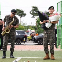 兵役を終えたBTSのRMさん（左）とVさん＝韓国北部・春川で2025年6月10日、ロイター