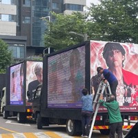 BTSが所属するHYBE本社周辺には、RMさんとVさんの除隊を祝うためファンが用意したメッセージ付きのトラックが並んだ＝ソウル市内のHYBE本社近くで2025年6月10日午前、堀山明子撮影