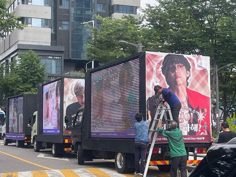 BTSが所属するHYBE本社周辺には、RMさんとVさんの除隊を祝うためファンが用意したメッセージ付きのトラックが並んだ＝ソウル市内のHYBE本社近くで2025年6月10日午前、堀山明子撮影
