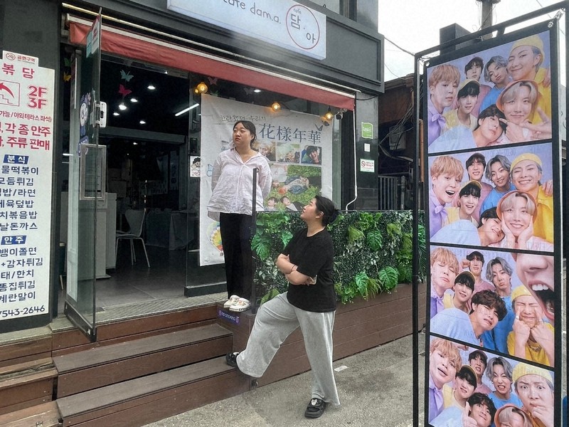 BTSが所属するHYBE本社周辺のカフェに掲げられた、メンバーの除隊を祝うポスター＝ソウル市内のHYBE本社近くで2025年6月10日午前、堀山明子撮影