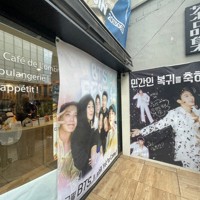 BTSが所属するHYBE本社周辺のカフェに掲げられた、メンバーの除隊を祝うポスター＝ソウル市内のHYBE本社近くで2025年6月10日午前、堀山明子撮影