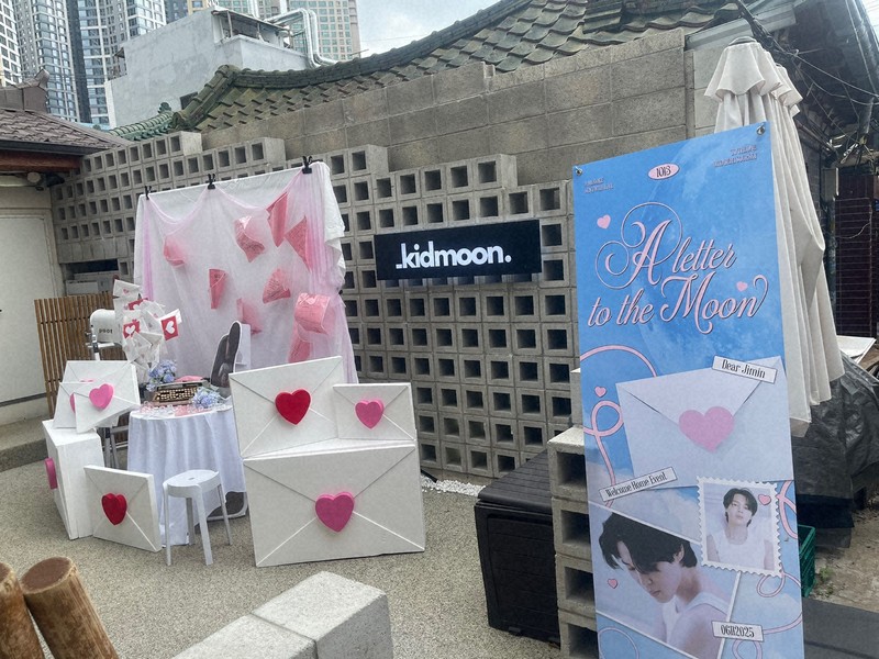 BTSが所属するHYBE本社周辺のカフェに掲げられた、メンバーの除隊を祝うポスター＝ソウル市内のHYBE本社近くで2025年6月10日午前、堀山明子撮影