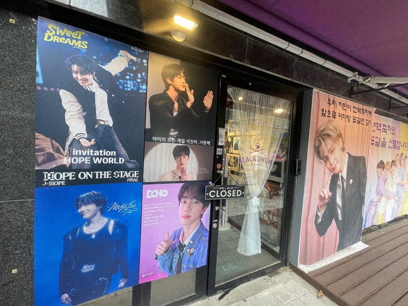 BTSが所属するHYBE本社周辺のカフェに掲げられた、メンバーの除隊を祝うポスター＝ソウル市内のHYBE本社近くで2025年6月10日午前、堀山明子撮影