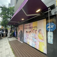 BTSが所属するHYBE本社周辺のカフェに掲げられた、メンバーの除隊を祝うポスター＝ソウル市内のHYBE本社近くで2025年6月10日午前、堀山明子撮影