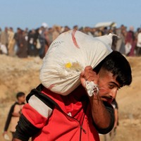 受け取った支援物資を運ぶ男性=パレスチナ自治区ガザ地区南部ハンユニスで2025年5月29日、ロイター