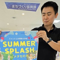 「SUMMER　SPLASH　inメタセの杜」のポスターをPRする町職員＝福岡県築上町の町役場で2025年6月11日午前9時43分、出来祥寿撮影