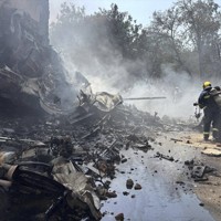 航空機の墜落現場で消火作業に当たる消防隊員ら＝インド西部アーメダバードで2025年6月12日、AP