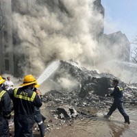 航空機が墜落した現場周辺で消火作業する消防士ら＝インド西部グジャラート州アーメダバードで2025年6月12日、ロイター