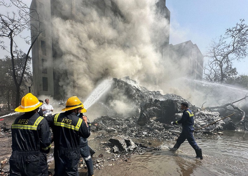 航空機が墜落した現場周辺で消火作業する消防士ら＝インド西部グジャラート州アーメダバードで2025年6月12日、ロイター