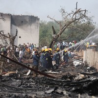 航空機が墜落した現場周辺で作業する人たち＝インド西部グジャラート州アーメダバードで2025年6月12日、ロイター