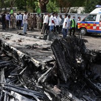 航空機が墜落した現場に集まる人たち＝インド西部グジャラート州アーメダバードで2025年6月12日、ロイター