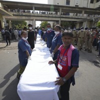 航空機が墜落した現場からの搬送者を待つ病院の職員ら＝インド西部グジャラート州アーメダバードで2025年6月12日、AP