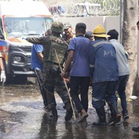 航空機の墜落現場で救助作業をする人たち＝インド西部グジャラート州アーメダバードで2025年6月12日、AP