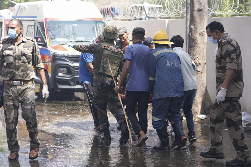 航空機の墜落現場で救助作業をする人たち＝インド西部グジャラート州アーメダバードで2025年6月12日、AP