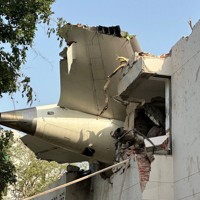 墜落して建物に引っかかった航空機の尾部＝インド西部グジャラート州アーメダバードで2025年6月12日、ロイター
