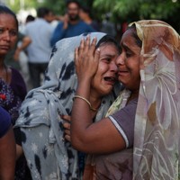 航空機が墜落し、家族の訃報に涙を流す女性＝インド西部グジャラート州アーメダバードで2025年6月12日、ロイター