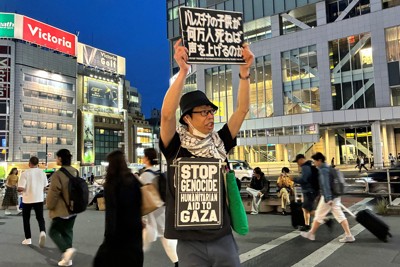 プラカードを掲げ、毎日1人で街頭に立つ古澤裕介さん＝東京都新宿区のJR新宿駅東南口前で2025年5月23日午後7時4分、千脇康平撮影