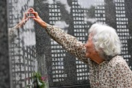 沖縄慰霊の日に「平和の礎」を訪れ、刻まれた母親の名前に触れて涙をこらえる女性＝沖縄県糸満市の平和祈念公園で2024年6月23日午前8時1分、野田武撮影