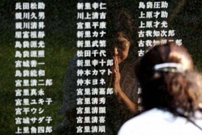 「平和の礎」で手を合わせる女性（62）は子供用のジュースやお菓子の供え物も用意した。戦時中、妊娠中だった伯母は南洋で犠牲になった＝沖縄県糸満市で2025年6月23日午前6時35分、喜屋武真之介撮影